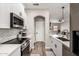 Kitchen with stainless steel appliances, white cabinets, and open layout to living space at 1411 E Orangewood Ave # 233, Phoenix, AZ 85020