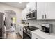 Updated kitchen with white cabinets, stainless steel appliances, and sleek countertops at 1411 E Orangewood Ave # 233, Phoenix, AZ 85020