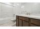 Bathroom boasts a shower and tub combo, vanity with sink, modern fixtures and lighting at 15389 W Cottontail Ln, Surprise, AZ 85387