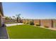 Expansive backyard with a manicured lawn, vibrant flowerbeds, offering a private and serene outdoor retreat at 15862 W Fillmore St, Goodyear, AZ 85338