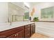 Elegant bathroom with a double sink vanity, large mirror, decorative tile, and soaking tub at 15862 W Fillmore St, Goodyear, AZ 85338