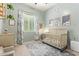 This light blue Bedroom features a crib, changing table, leaf-patterned curtains, and a patterned rug at 15862 W Fillmore St, Goodyear, AZ 85338