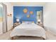 Bright bedroom showcasing a blue accent wall, two side tables, lamps, and a queen-size bed at 15862 W Fillmore St, Goodyear, AZ 85338