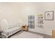 Lovely Bedroom featuring a white crib, whimsical polka-dot wallpaper, and charming decorative shelves and framed art at 15862 W Fillmore St, Goodyear, AZ 85338