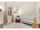 Charming Bedroom with a white crib, a cozy armchair, and beautiful decor details that creates a warm atmosphere at 15862 W Fillmore St, Goodyear, AZ 85338