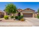 Inviting single-story home boasts a well-manicured front yard and a two-car garage, creating a warm and welcoming curb appeal at 15862 W Fillmore St, Goodyear, AZ 85338