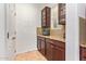 This pantry has granite countertops, wood cabinets, tile backsplash, and tile floors at 15862 W Fillmore St, Goodyear, AZ 85338