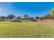 Community playground featuring a large grassy area, playground equipment and mature trees, perfect for Gathering fun and recreation at 15862 W Fillmore St, Goodyear, AZ 85338
