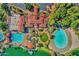 Aerial view highlighting community amenities: a pool, lagoon, clubhouse, and meticulously manicured lawns at 1633 E Lakeside Dr # 127, Gilbert, AZ 85234