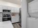 Modern kitchen featuring white cabinets, stainless steel appliances, and a stylish backsplash; includes a washer and dryer unit at 1633 E Lakeside Dr # 127, Gilbert, AZ 85234