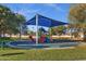 A colorful playground featuring a sunshade over slides, ladders, and benches in a neighborhood park at 1633 E Lakeside Dr # 127, Gilbert, AZ 85234