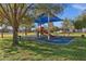 A colorful playground featuring a sunshade over slides, ladders, and benches in the park at 1633 E Lakeside Dr # 127, Gilbert, AZ 85234