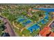 Aerial shot of multiple well-maintained tennis courts surrounded by lush greenery and community homes at 1633 E Lakeside Dr # 127, Gilbert, AZ 85234