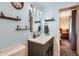 Charming bathroom with light blue walls, floating shelves, a modern vanity, and decorative mirror at 1718 W Voltaire Ave, Phoenix, AZ 85029