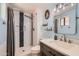 Stylish bathroom featuring a tiled shower with a glass door and a modern vanity with decorative mirror at 1718 W Voltaire Ave, Phoenix, AZ 85029