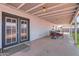 Spacious covered patio with double doors leading to a lush, green backyard at 1718 W Voltaire Ave, Phoenix, AZ 85029