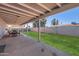 Large covered patio with a dining table and chairs overlooking the manicured lawn at 1718 W Voltaire Ave, Phoenix, AZ 85029