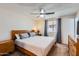 Comfortable bedroom with wood furnishings, a ceiling fan, and a window providing natural light at 1718 W Voltaire Ave, Phoenix, AZ 85029