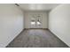 A carpeted bedroom with white walls and glass paneled doors leading to the back yard at 1739 E Carter Rd, Phoenix, AZ 85042