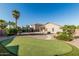 Expansive backyard featuring a putting green, trampoline, and desert landscaping at 19576 N Portarosa Ct, Maricopa, AZ 85138