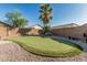 Backyard featuring desert landscaping, a putting green, and privacy wall at 19576 N Portarosa Ct, Maricopa, AZ 85138