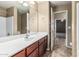 Well-lit bathroom with a large mirror, sink, and convenient access to an adjacent room at 19576 N Portarosa Ct, Maricopa, AZ 85138