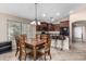 Open-concept kitchen with dark cabinetry, stainless steel appliances, tile floors, and an eat-in area at 19576 N Portarosa Ct, Maricopa, AZ 85138