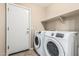 Functional laundry room featuring a modern washer and dryer, plus handy shelving at 19576 N Portarosa Ct, Maricopa, AZ 85138