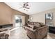 Comfortable living room with a ceiling fan, neutral color palette, and sliding glass doors to the outdoor patio at 19576 N Portarosa Ct, Maricopa, AZ 85138