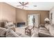 Cozy living room featuring neutral colors, a ceiling fan, and sliding glass doors to the backyard patio at 19576 N Portarosa Ct, Maricopa, AZ 85138