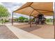 Community playground featuring covered play structures, swings, and picnic area for Gathering outings at 19576 N Portarosa Ct, Maricopa, AZ 85138