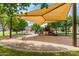 Shaded community playground with a variety of play structures for enjoyment at 19576 N Portarosa Ct, Maricopa, AZ 85138