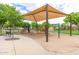 Well-maintained playground with swings, slides, and a covered seating area for children at 19576 N Portarosa Ct, Maricopa, AZ 85138