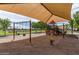 Covered playground with swings and climbing structures, providing a fun and shaded area for play at 19576 N Portarosa Ct, Maricopa, AZ 85138