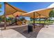 Shaded playground with a variety of play equipment, offering a comfortable and engaging space for children at 19576 N Portarosa Ct, Maricopa, AZ 85138
