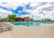 Stunning community pool with sun loungers and a covered lounge area on a sunny day at 19576 N Portarosa Ct, Maricopa, AZ 85138