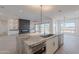Bright, open kitchen with an oversized island featuring a granite countertop and sleek, modern stainless steel appliances at 2005 W Lincoln Ct, Queen Creek, AZ 85144