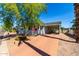 Charming home exterior with an American flag, mature tree, and ample parking at 201 S Greenfield Rd # 29, Mesa, AZ 85206