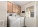 Bright laundry room with washer, dryer, overhead cabinets, and access to the exterior at 201 S Greenfield Rd # 29, Mesa, AZ 85206