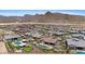 Wide aerial view of many homes, some with pools, set amidst mountains and lush desert landscaping at 20795 W San Juan Ave, Buckeye, AZ 85396