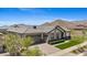 Aerial view of a home featuring mountain views, mature desert landscaping, and many desert homes at 20795 W San Juan Ave, Buckeye, AZ 85396