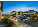 Beautifully landscaped backyard featuring a fire pit, outdoor dining, and putting green at 20795 W San Juan Ave, Buckeye, AZ 85396