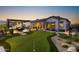 Backyard with putting green, outdoor dining, and lounge area at dusk at 20795 W San Juan Ave, Buckeye, AZ 85396