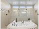 Bathroom featuring a luxurious soaking tub, tiled walls, and and shower heads at 20795 W San Juan Ave, Buckeye, AZ 85396