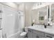 Clean bathroom featuring a shower-tub combo with white tile surround, vanity, and modern lighting at 20795 W San Juan Ave, Buckeye, AZ 85396
