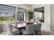 Dining area featuring large windows, modern chandelier, and views of the backyard oasis at 20795 W San Juan Ave, Buckeye, AZ 85396