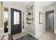 Stylish home entryway with a modern black door, decorative shelving, and elegant interior design at 20795 W San Juan Ave, Buckeye, AZ 85396
