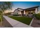 Well-maintained single-story home showcasing a tidy lawn and a covered porch with comfortable seating at 20795 W San Juan Ave, Buckeye, AZ 85396