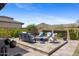 Backyard with mountain views features cozy fire pit seating area and lush landscaping at 20795 W San Juan Ave, Buckeye, AZ 85396