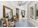 Bright foyer with decorative tile rug, contemporary lighting and seating, plus large mirror to provide more light at 20795 W San Juan Ave, Buckeye, AZ 85396